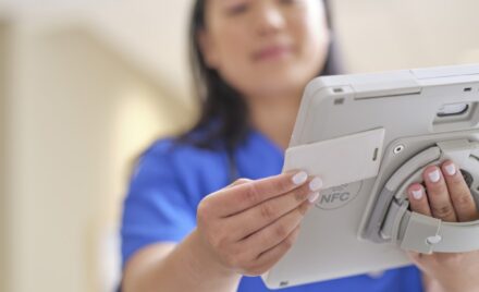 A nurse is holding Surface Go 3 in a ruggedized case.