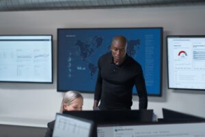 Practitioner and C I S O collaborate in a security operations center.