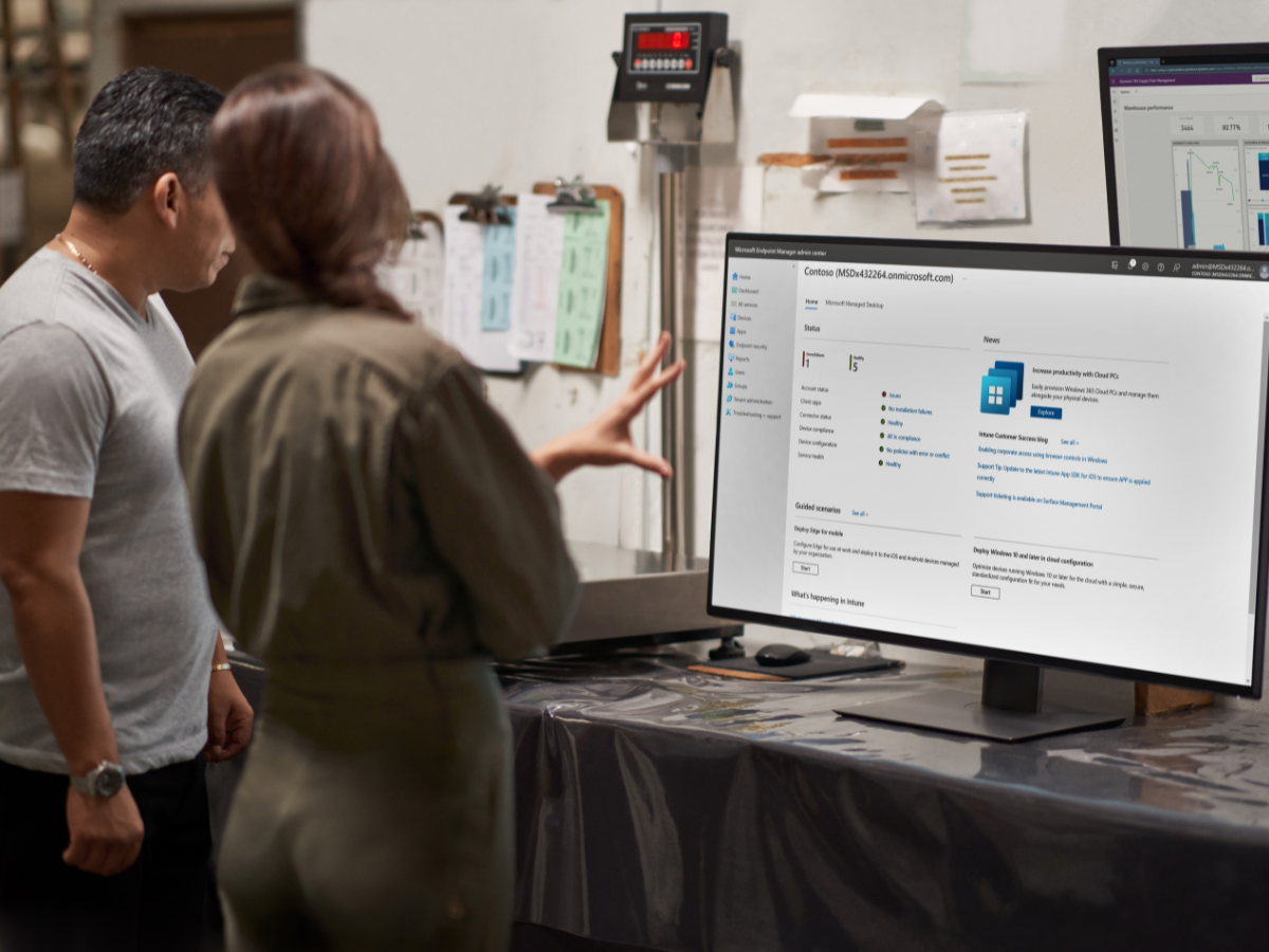 Two people looking at a computer monitor of Microsoft Endpoint Manager.