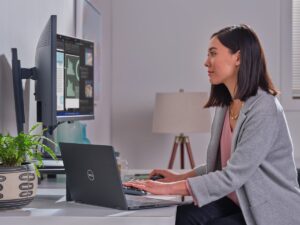 Business person uses Dell 7520 2-in-1 connected to dual monitors at their home office.