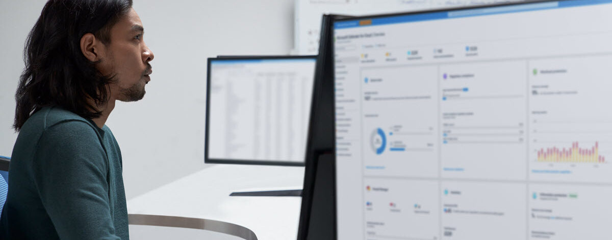A person sitting at a desk in front of a laptop computer