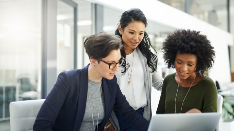 Shot of a group of businesswomen using a laptop during a meeting at work.