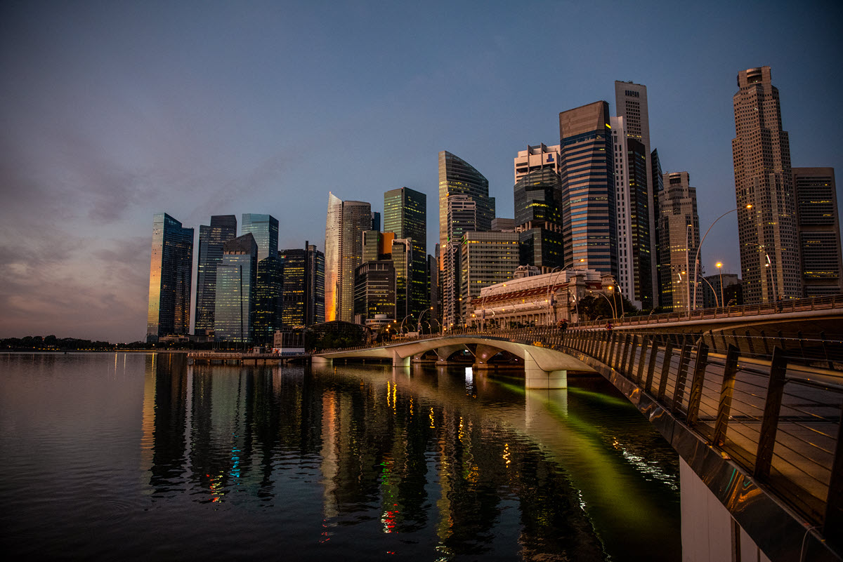 a long bridge over a body of water with a city in the background