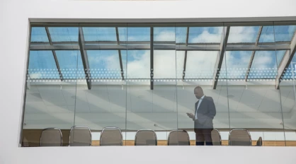 Photo of a man in a meeting room using phone.