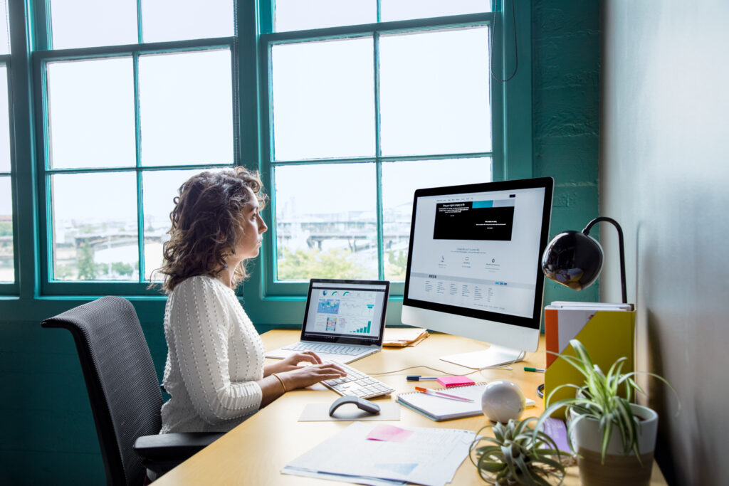 A woman works at a desktop computer.