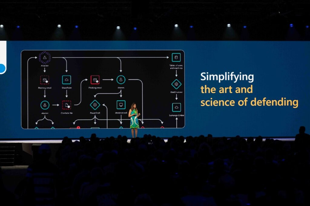 Vasu Jakkal presenting in front of a screen that says "Simplifying the art and science of defending."