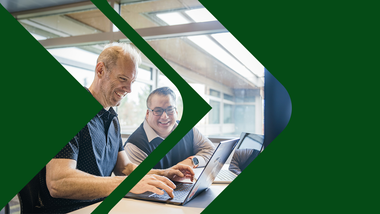 Two security professionals at a computer with a green Microsoft security template applied on the image.