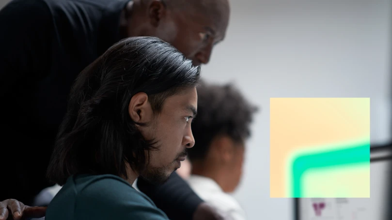A group of men looking at a computer screen.