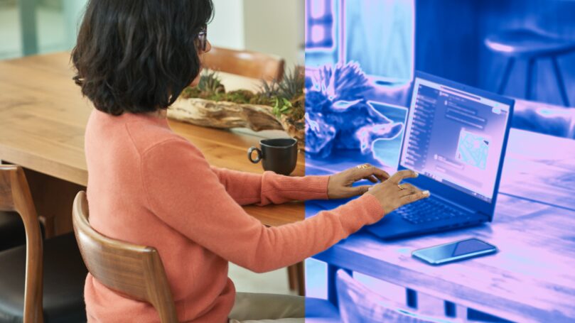 Woman sitting at desk typing on laptop