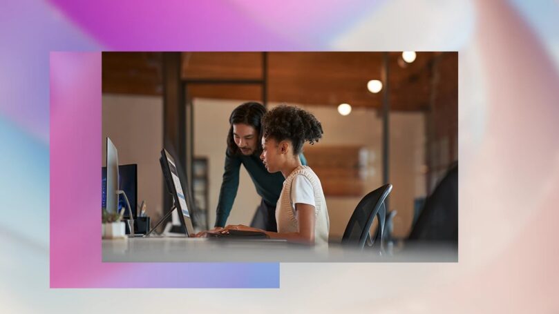 Two people sit at a computer.
