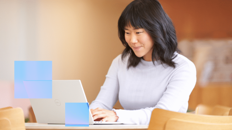 A woman types on a laptop.