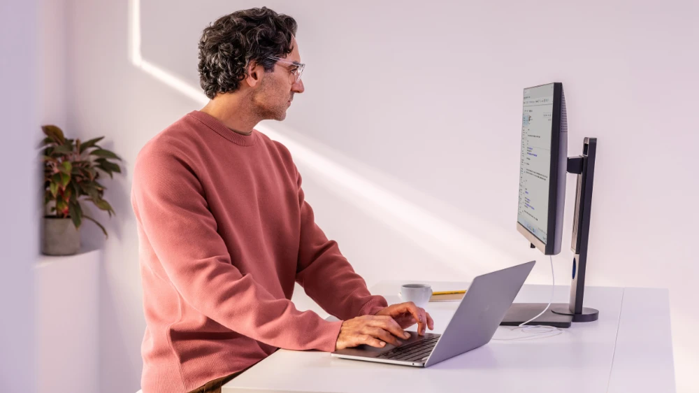 Man in focused work; able to do secure banking on a laptop at home or at the office.