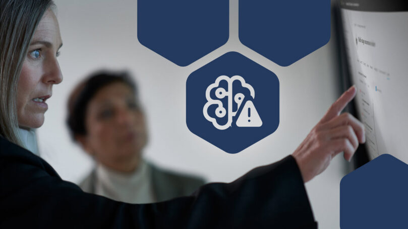 Two women pointing at a screen