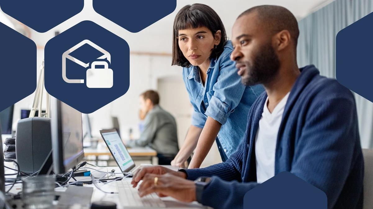 Two office workers looking at a desktop monitor