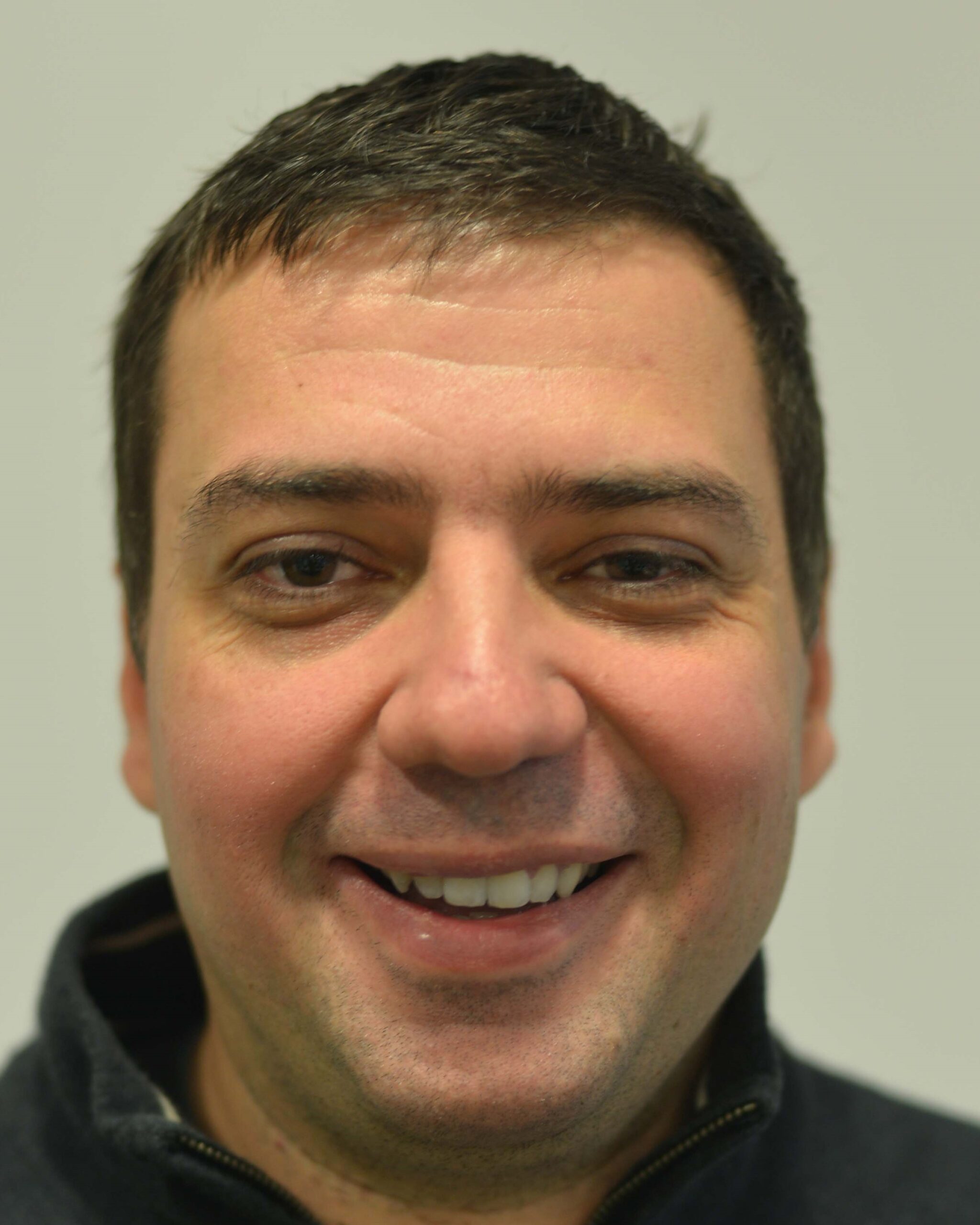 Author headshot of a man smiling at the camera.