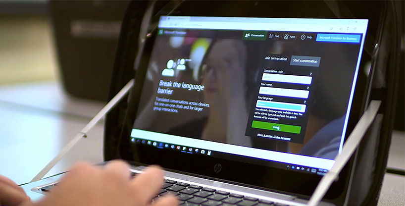 En studerende på deres bærbare computer ved hjælp af Translator multi-enhed samtale funktion i deres browser.