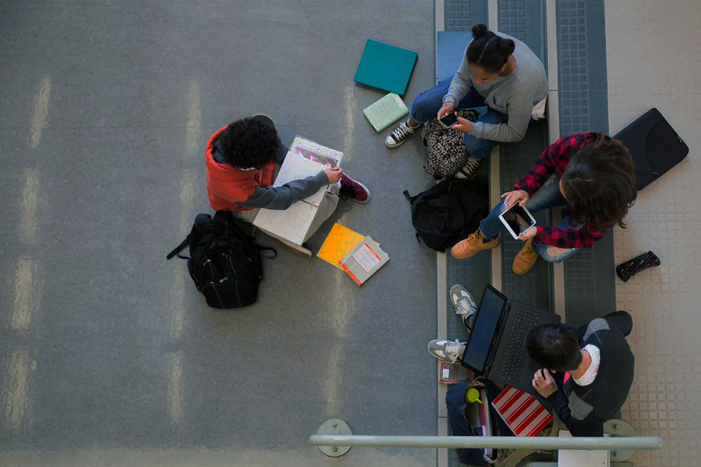Luftfoto af teenagere på deres bærbare computere, tablets og telefoner