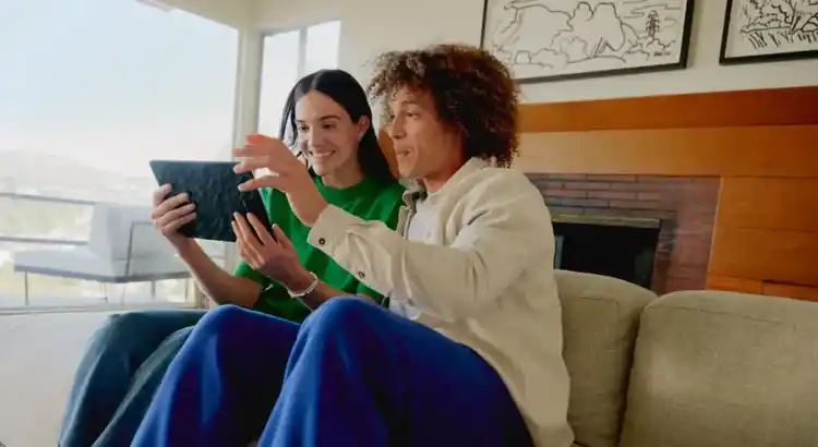 Casual digital interaction in stylish living room with scenic view, tablet use, and cozy atmosphere.