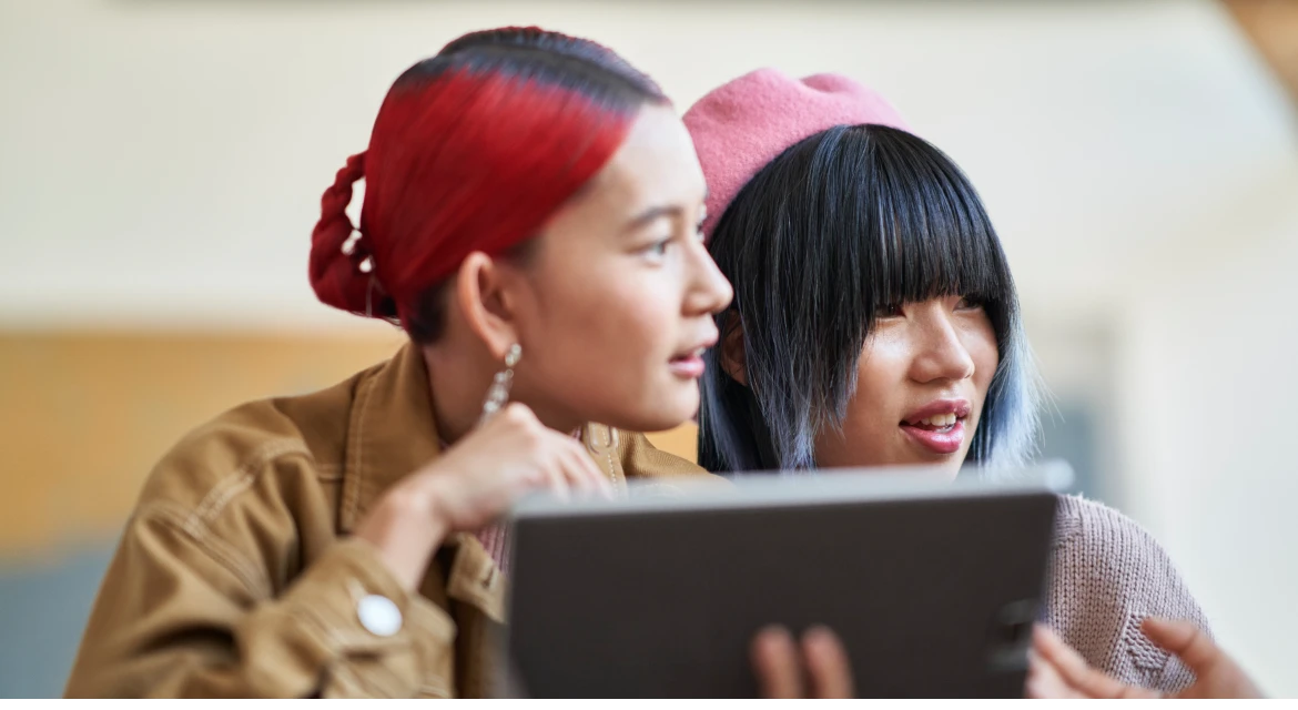 a man and a woman looking at a laptop