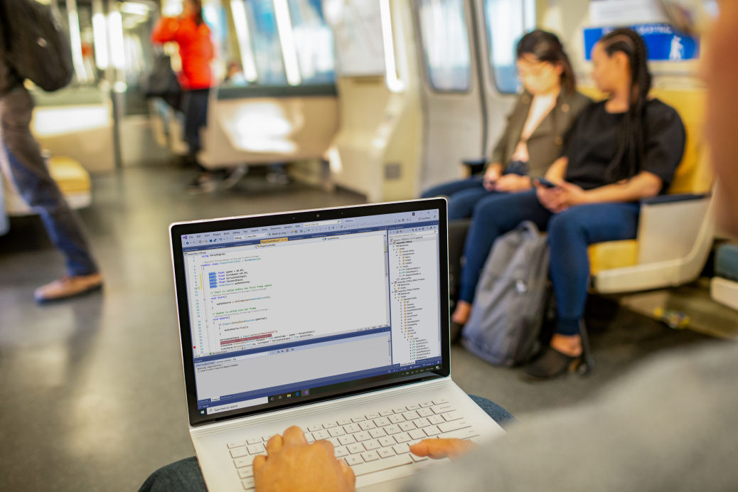 A man using his laptop in the metro.