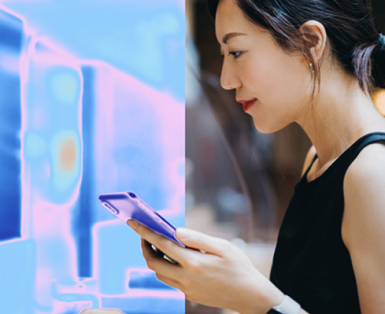 Person using a smartphone beside a glowing digital display interface.
