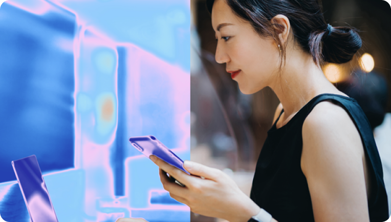 Person using a smartphone beside a glowing digital display interface.