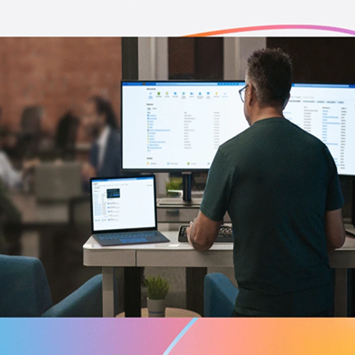 man standing in front of a screen and a laptop. Office area in the background