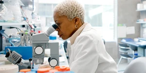 Mujer en un laboratorio mirando al microscopio