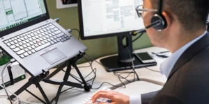 Una persona frente a dos computadoras en una oficina