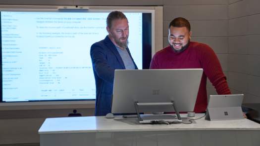 Dos hombres mirando la pantalla de una computadora.
