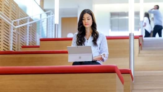 Una mujer sentada en las escaleras, utilizando una laptop 