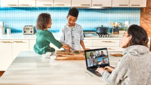 Une femme travaille sur son ordinateur en gardant ses enfants.