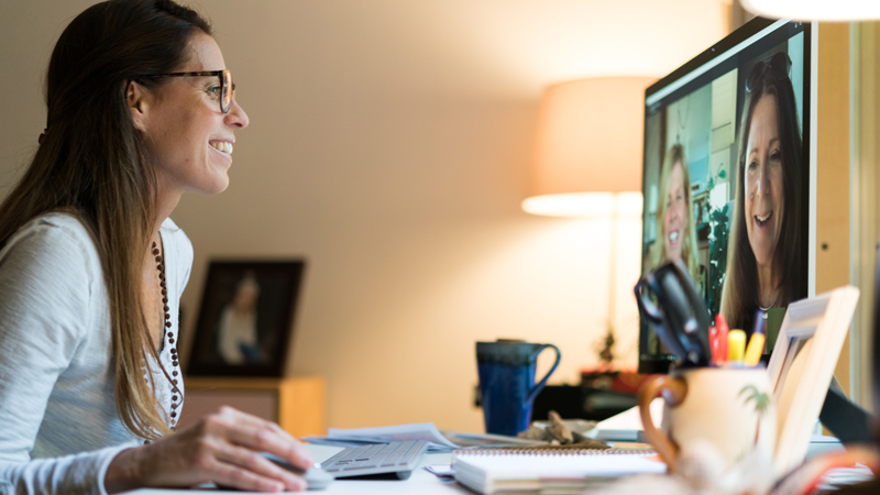 Une femme utilisant la vidéoconférence Skype pour assister à une réunion de travail.