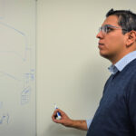 Paul Rojas looks at a whiteboard drawing of the Azure optimization recommendation platform.