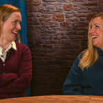 Sarah Lundy and Rachelle Blanchard share a laugh while sitting at a video studio desk on the Microsoft campus.
