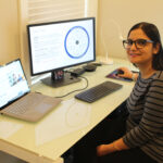 Darshana Pandya sits at her desk and smiles. Her computer monitor displays a slide that lists the elements of a Zero Trust security model.