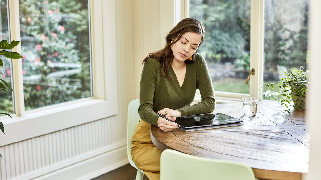 A Microsoft employee works from their dining table at their home.