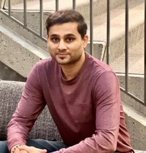 Ganesh looks at the camera while sitting in an open space in a Microsoft building.