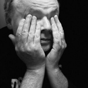  Peyton poses in a black and white dramatization with his head in his hands.