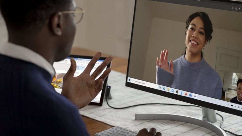 Male and female coworkers on Microsoft Teams call using webcam.