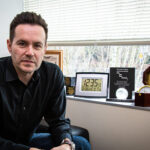 Ludo Hauduc leans forward from a seated position in his office and looks intently into the camera.