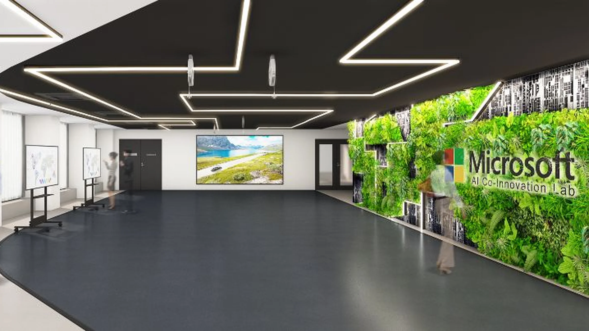 黄色いシャツを着て眼鏡をかけた男性がコンピューターの画面を指差しており、その横に座っている女性は熱心に見つめている。両者は現代的なオフィス環境で協力している。