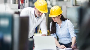 Two workers looking at a device in a manufacturing setting