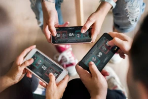 Group,Of,Diverse,Friends,Playing,Game,On,Mobile,Phone