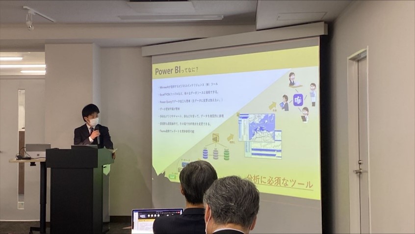 セミナールームで資料を投影しながらプレゼンを行う様子／「Power BI ってなに？」のスライド