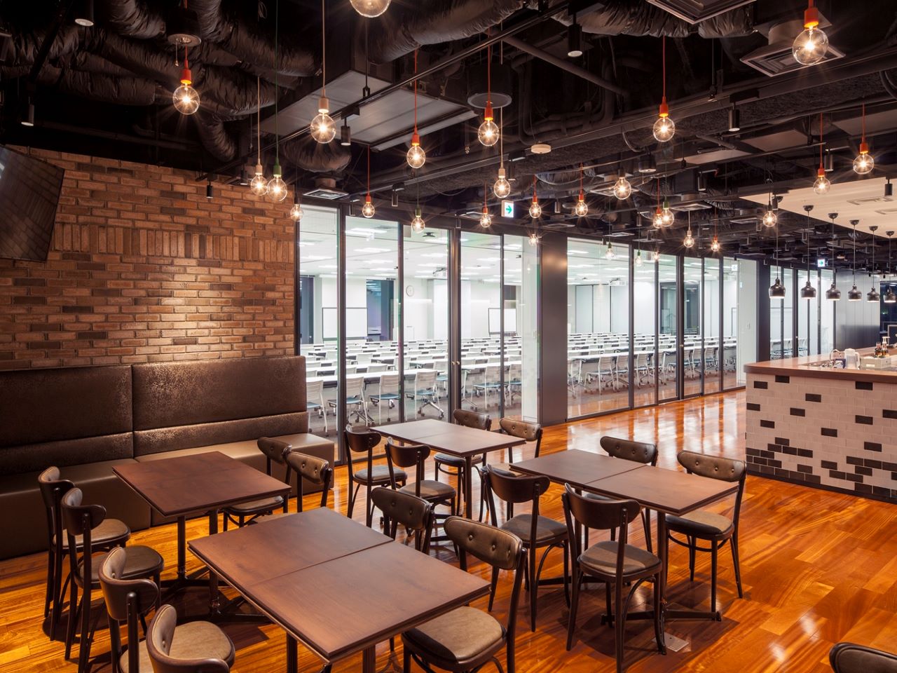 レンガ壁と裸電球が特徴のカフェスペース。