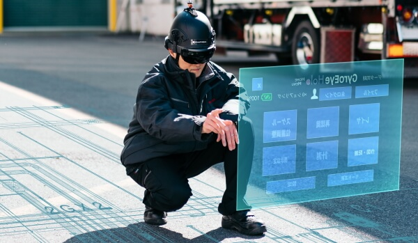 路上で 2D CAD 図面を操作するホロレンズを装着したエンジニア。