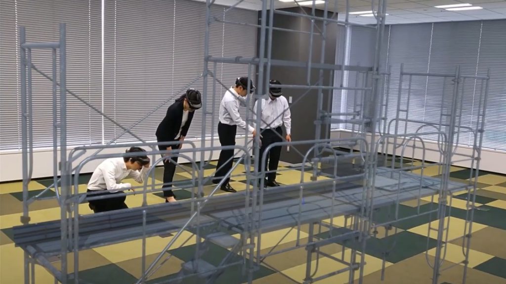 
 仮想マシンを装着した安全足場構造を検査する女性 1 人と男性 3 人