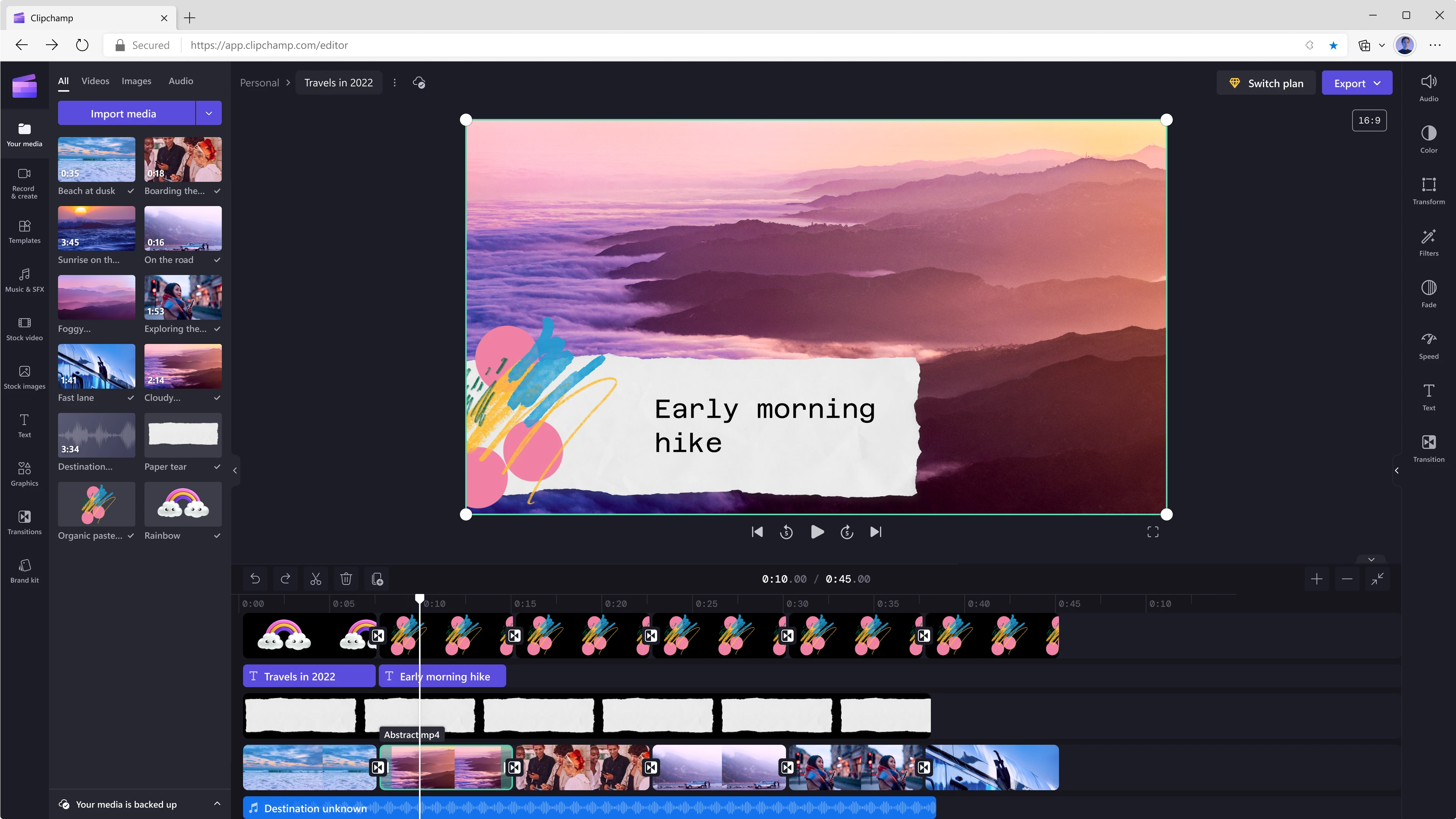 Een gebruiker bewerkt een video van 45 seconden met behulp van Clipchamp. Het frame bij de 10 seconden-markering toont bergen en wolken met een violette kleur, met de tekst 'Vroege ochtendwandeling' over het videoframe heen. 