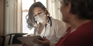 Médica olhando para dispositivo